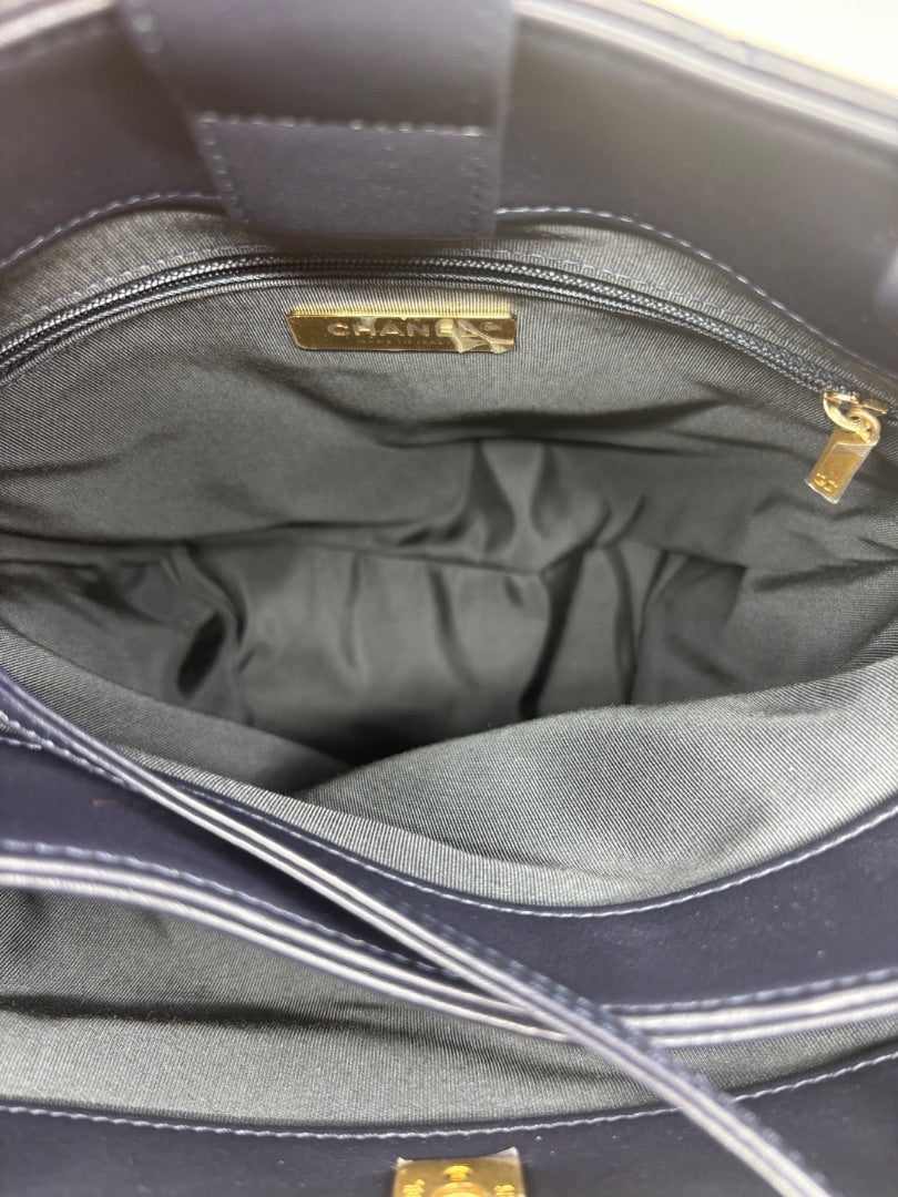 Posh Purse Co. Navy blue Chanel tote bag interior with gold logo and zipper detail.