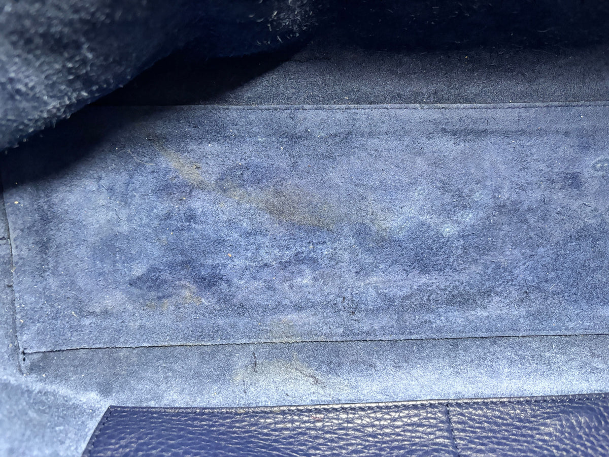 Interior base of Posh Purse Co preloved navy Valentino Rockstud tote showing signs of staining on the suede lining