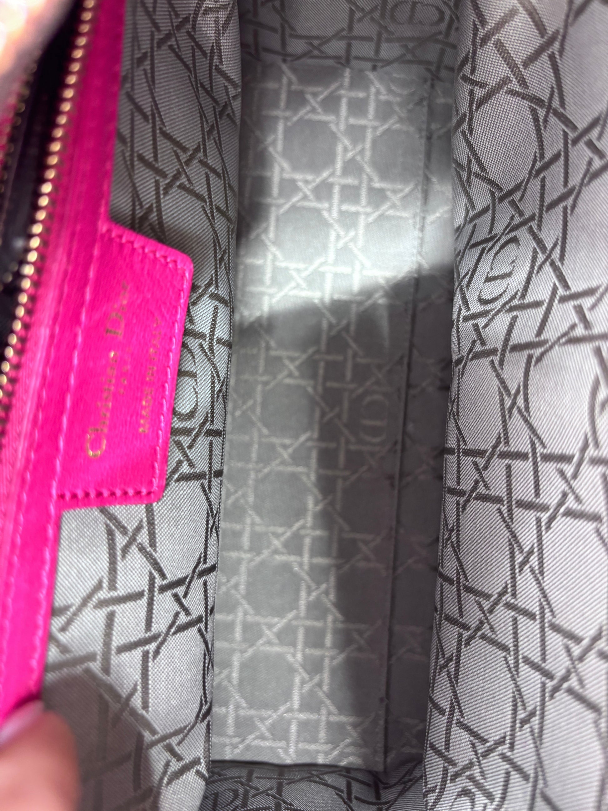 Interior of Posh Purse Co pink Lady Dior bag featuring grey logo-patterned fabric lining and pink leather tag