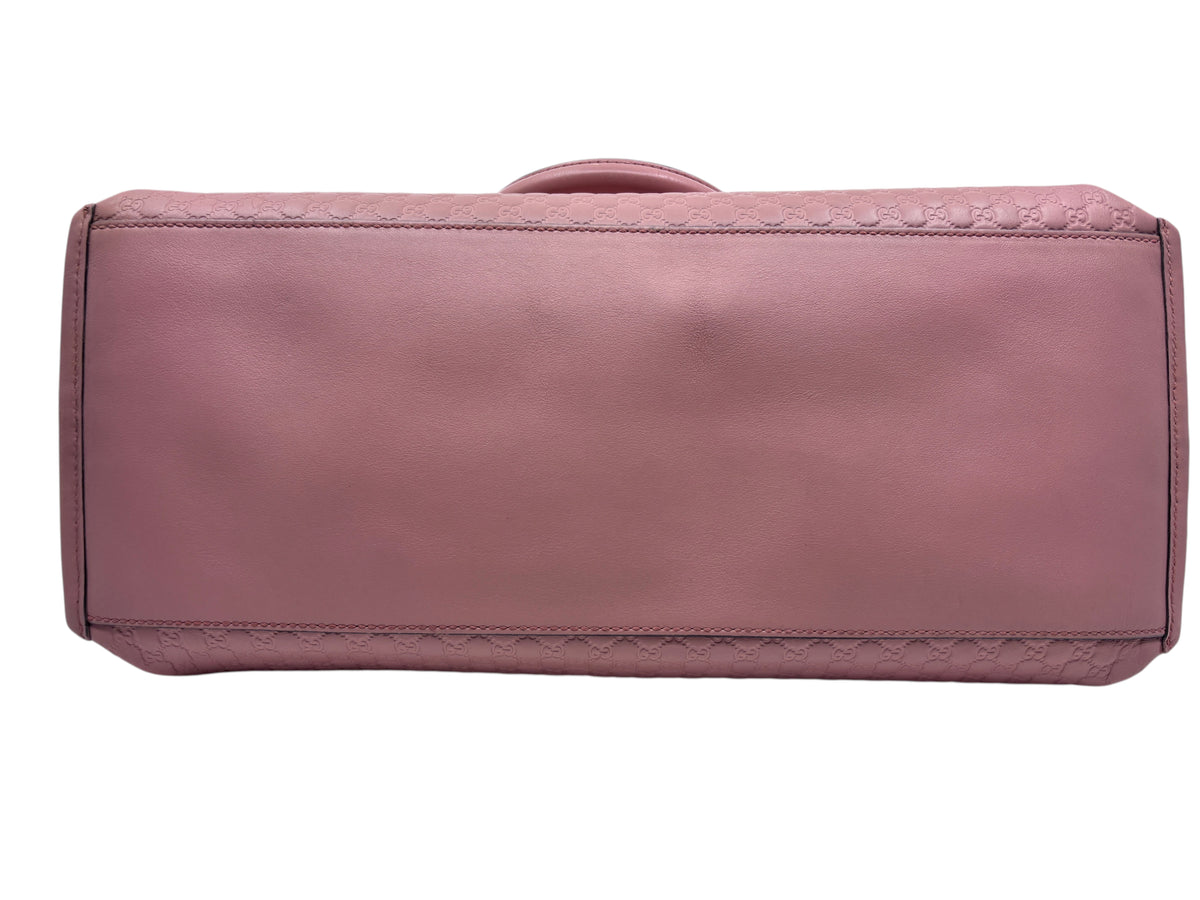 Bottom view of a pink Posh Purse Co Gucci Micro Guccissima leather handbag with embossed logo pattern