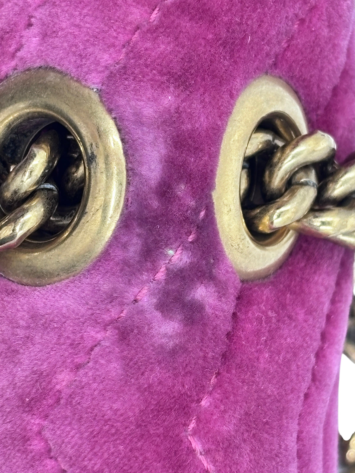 Close-up of Posh Purse Co pink velvet Gucci Marmont bag showing gold chain hardware and quilted texture detail.