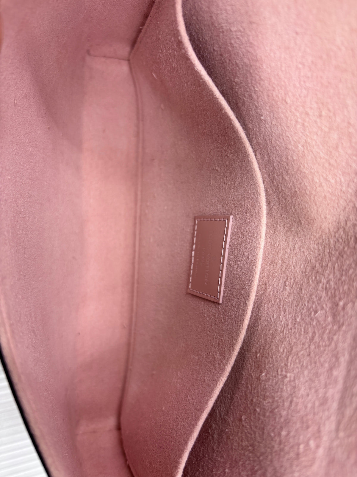 Interior of Posh Purse Co pink Louis Vuitton Epi leather Pochette Felicie showing the soft suede lining and logo patch