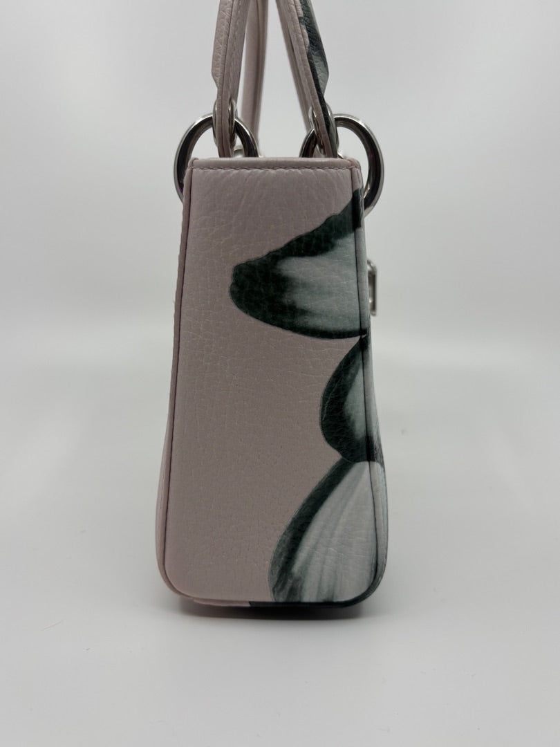 Side view of a preloved pink floral Mini Lady Dior bag with silver hardware, sold by Posh Purse Co.