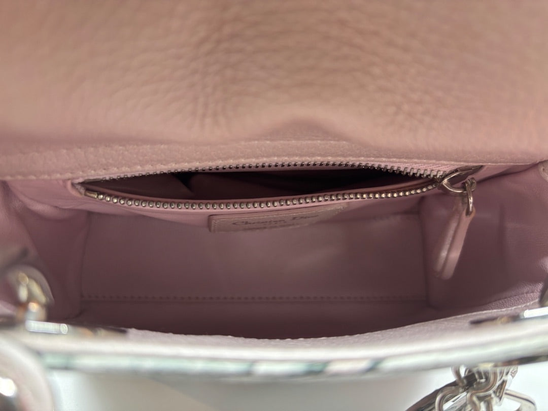 Interior of a preloved pink Mini Lady Dior bag with a zippered pocket and Christian Dior label from Posh Purse Co.