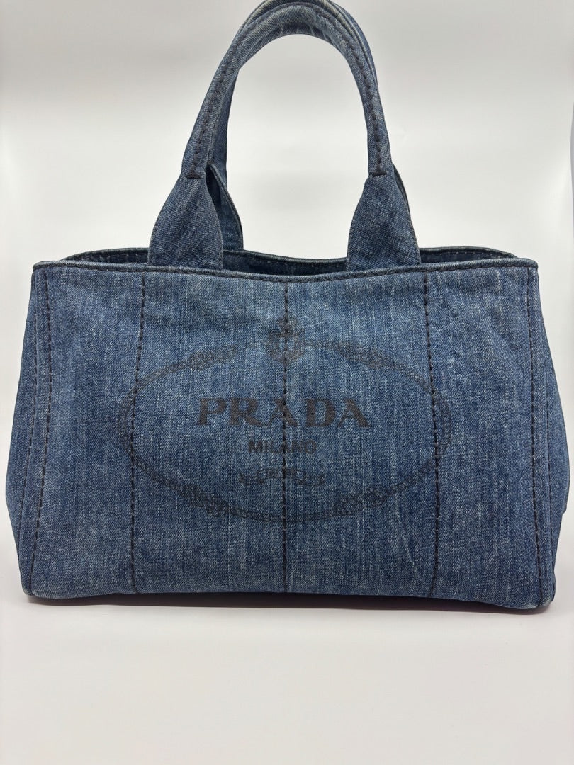 Posh Purse Co Prada Avio Denim Tote, blue denim handbag with large embossed logo and top handles.