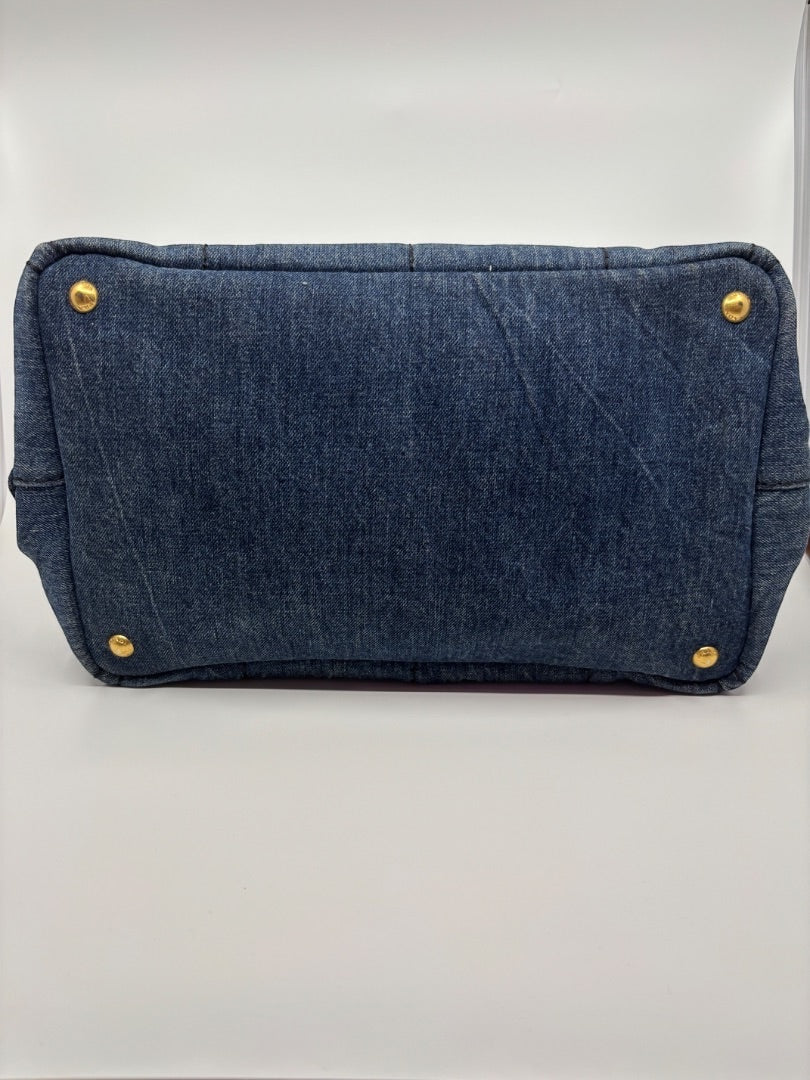Posh Purse Co Prada Avio Denim Tote, a blue denim handbag with gold-tone hardware and protective feet.