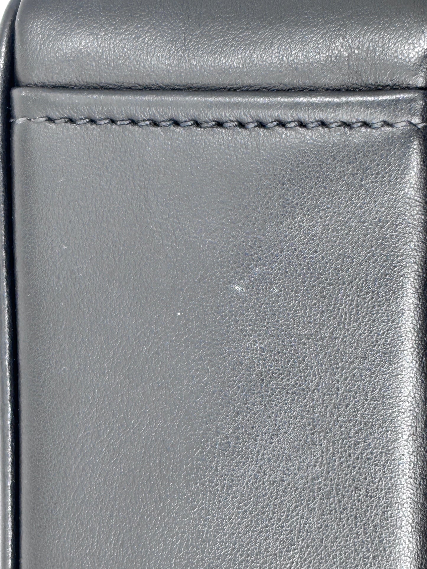Close-up of the smooth black leather texture and stitching on a Posh Purse Co Prada Mirage camera bag