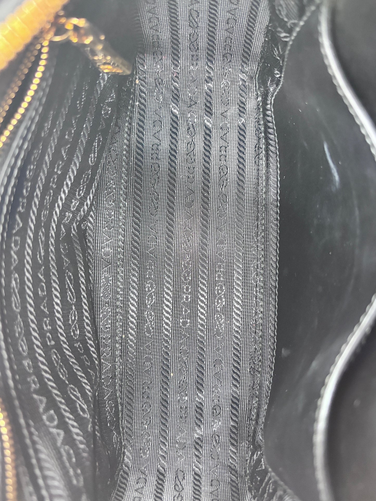 Interior of Posh Purse Co pre-owned Prada Mirage camera bag featuring black fabric with signature Prada monogram logo