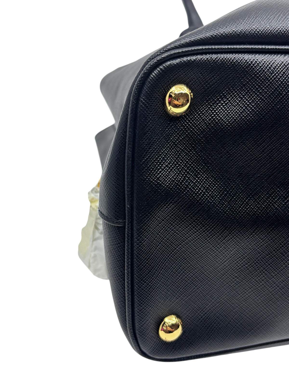 Posh Purse Co black Prada Saffiano leather tote bag showing gold-tone protective feet on the structured base