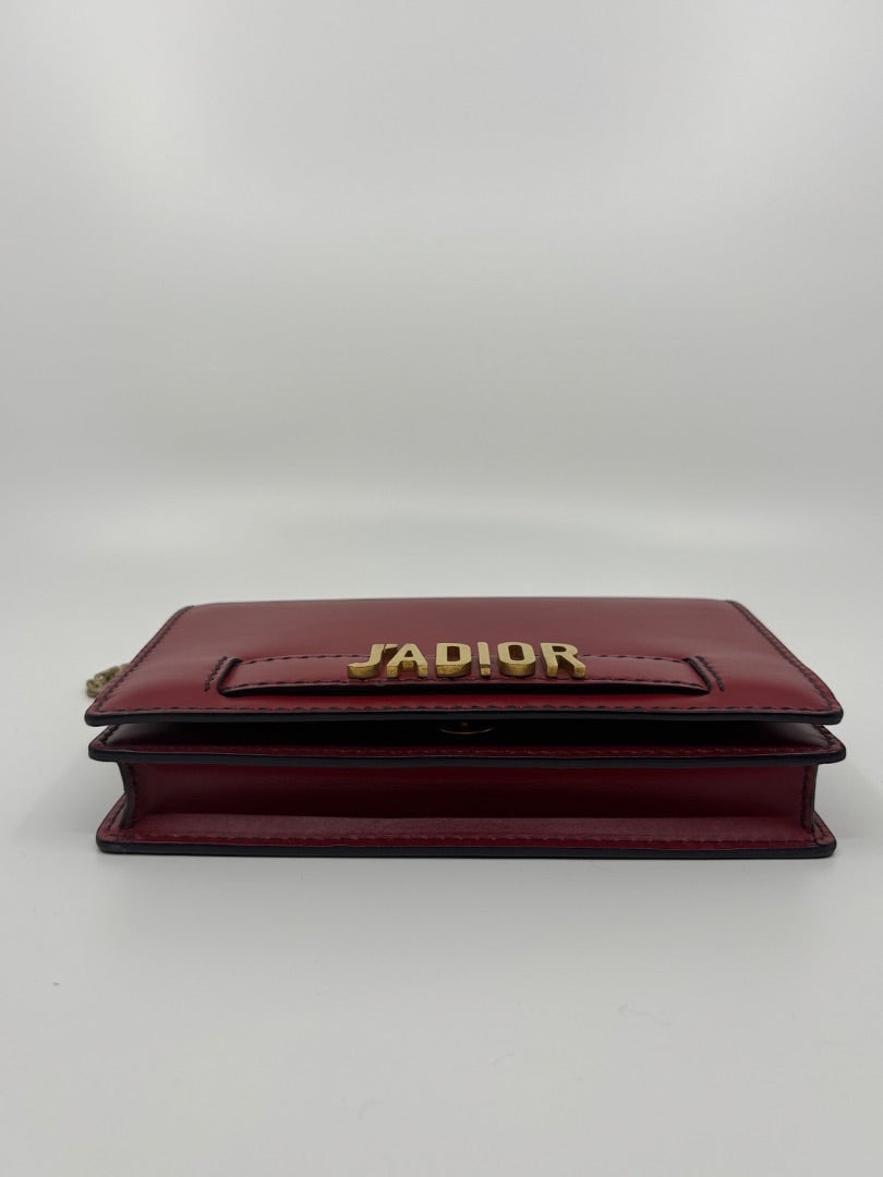 Posh Purse Co. red Dior J'adior crossbody bag with gold-tone logo hardware and structured leather silhouette.