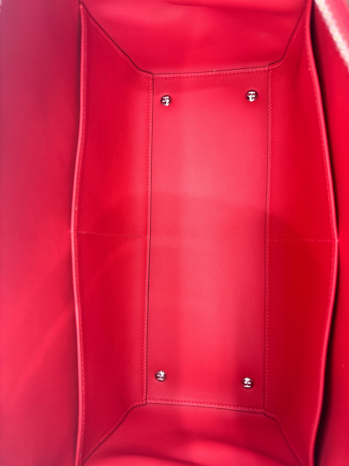 Interior of a brand new red Hermès Petit Tour 24 bag from Posh Purse Co featuring smooth leather and silver hardware