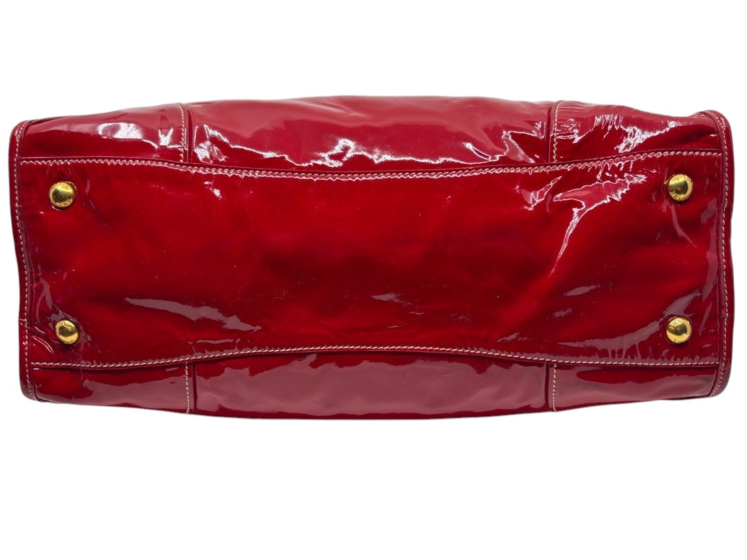 Posh Purse Co. red Prada Vernice patent leather shoulder bag base with gold-tone protective feet.