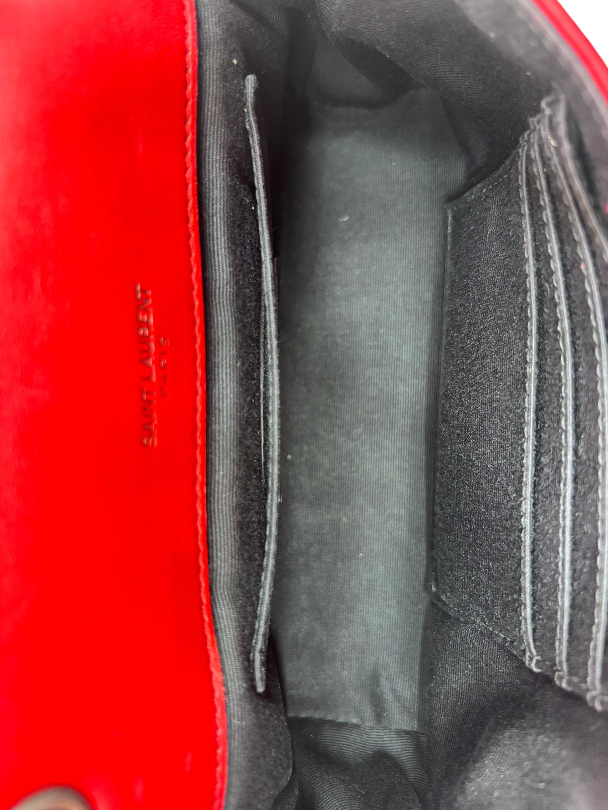 Interior view of a red Saint Laurent Jamie bag showing the black fabric lining and card slots from Posh Purse Co.