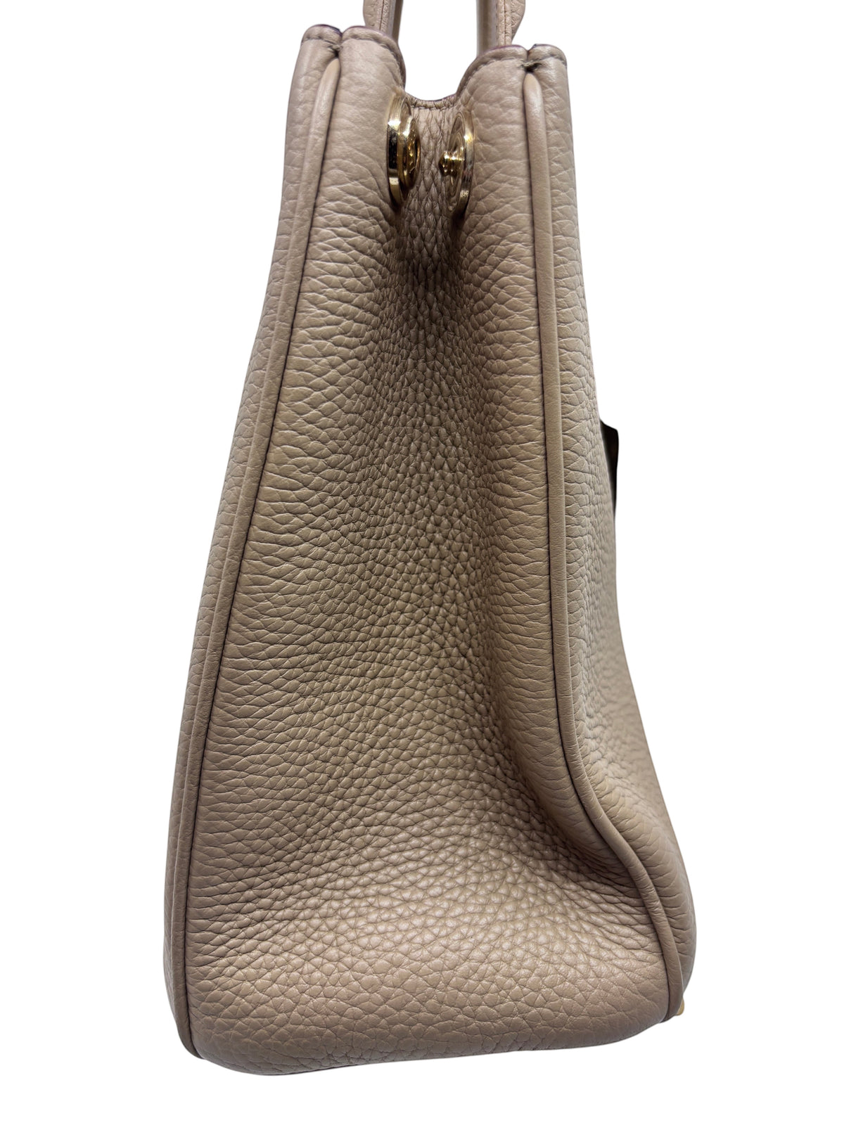 Side view of a tan Dior Diorissimo leather tote bag with pebbled texture and polished hardware from Posh Purse Co.
