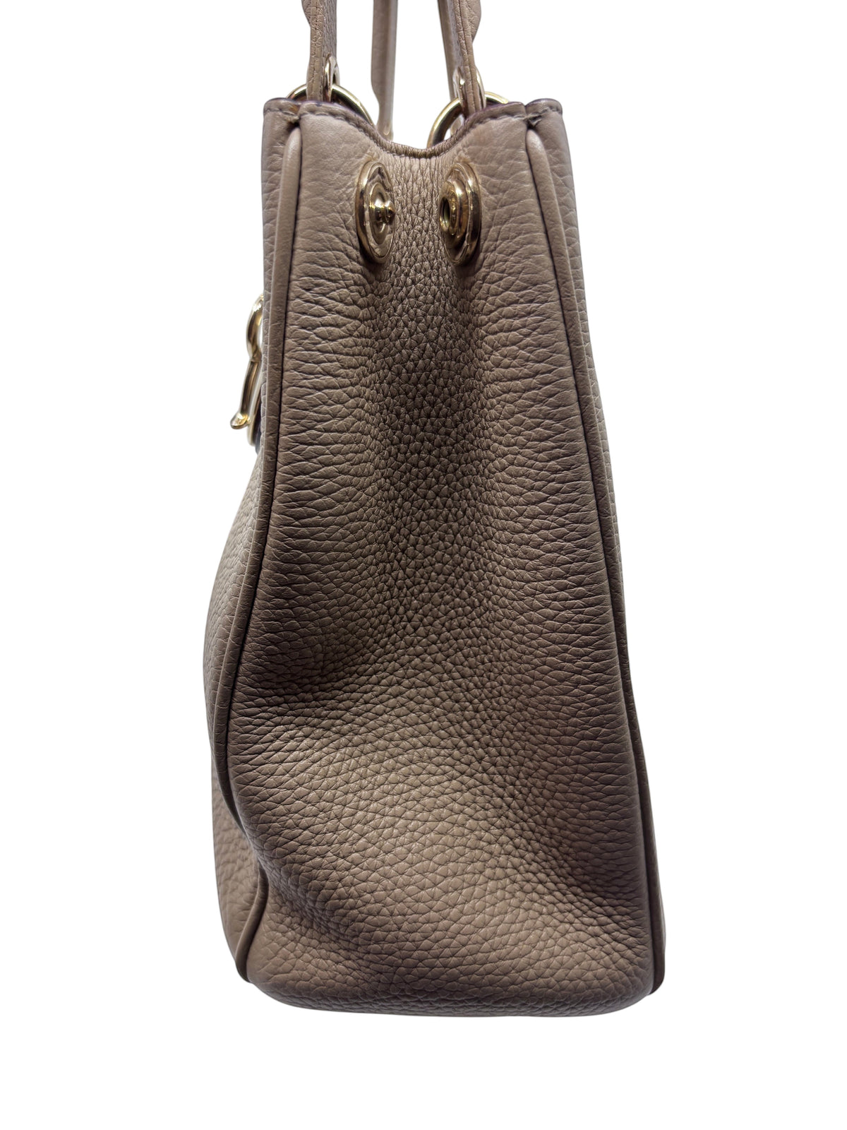 Side view of a Posh Purse Co tan Dior Diorissimo leather tote bag with textured grain and polished metal hardware