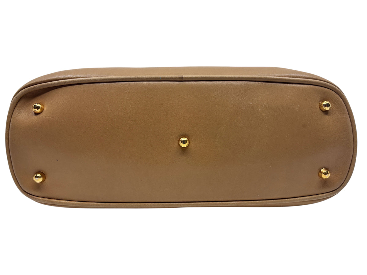 Base of a tan leather Gucci handbag from Posh Purse Co featuring five protective gold-tone metal feet.