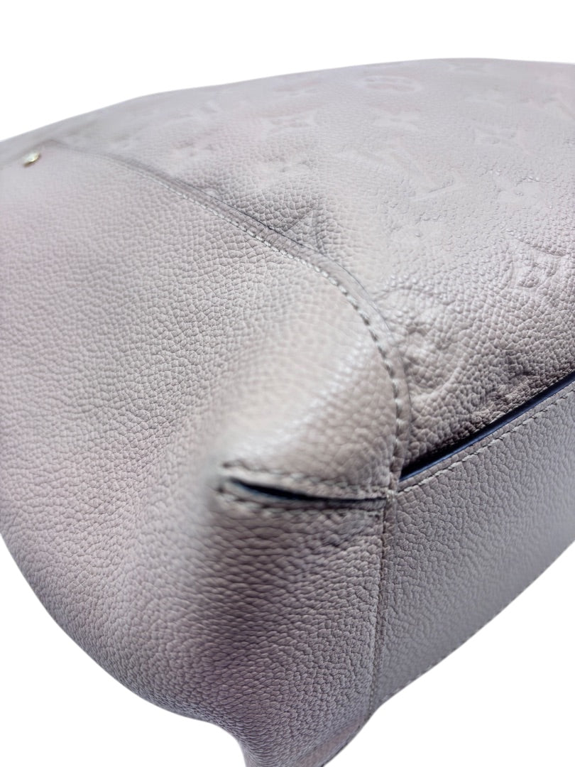 Close-up of tan Louis Vuitton Empreinte Bagatelle hobo bag corner showing embossed monogram leather by Posh Purse Co