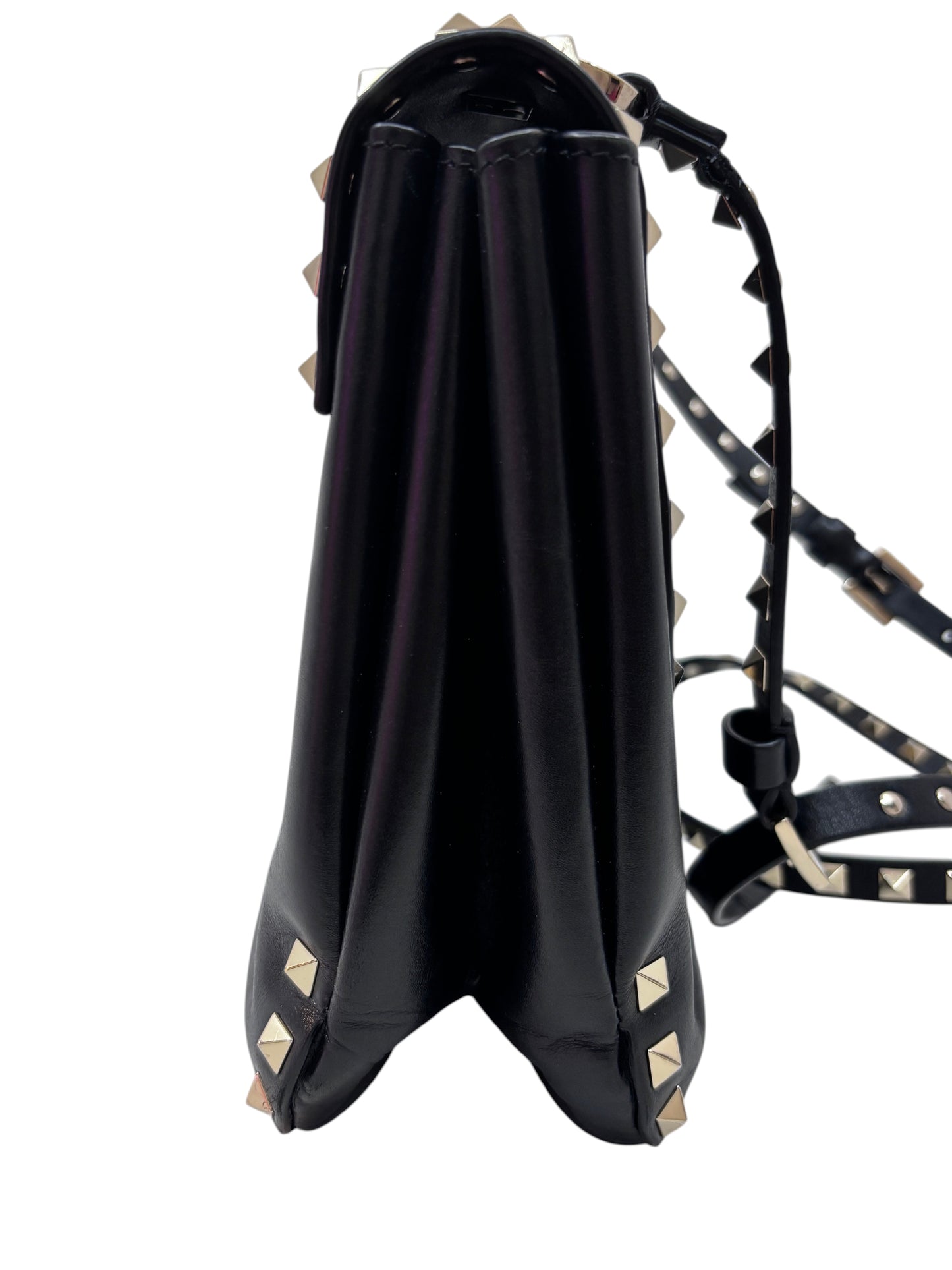 Side view of a black Posh Purse Co. Valentino Rockstud flap bag featuring signature gold studs and a shoulder strap.