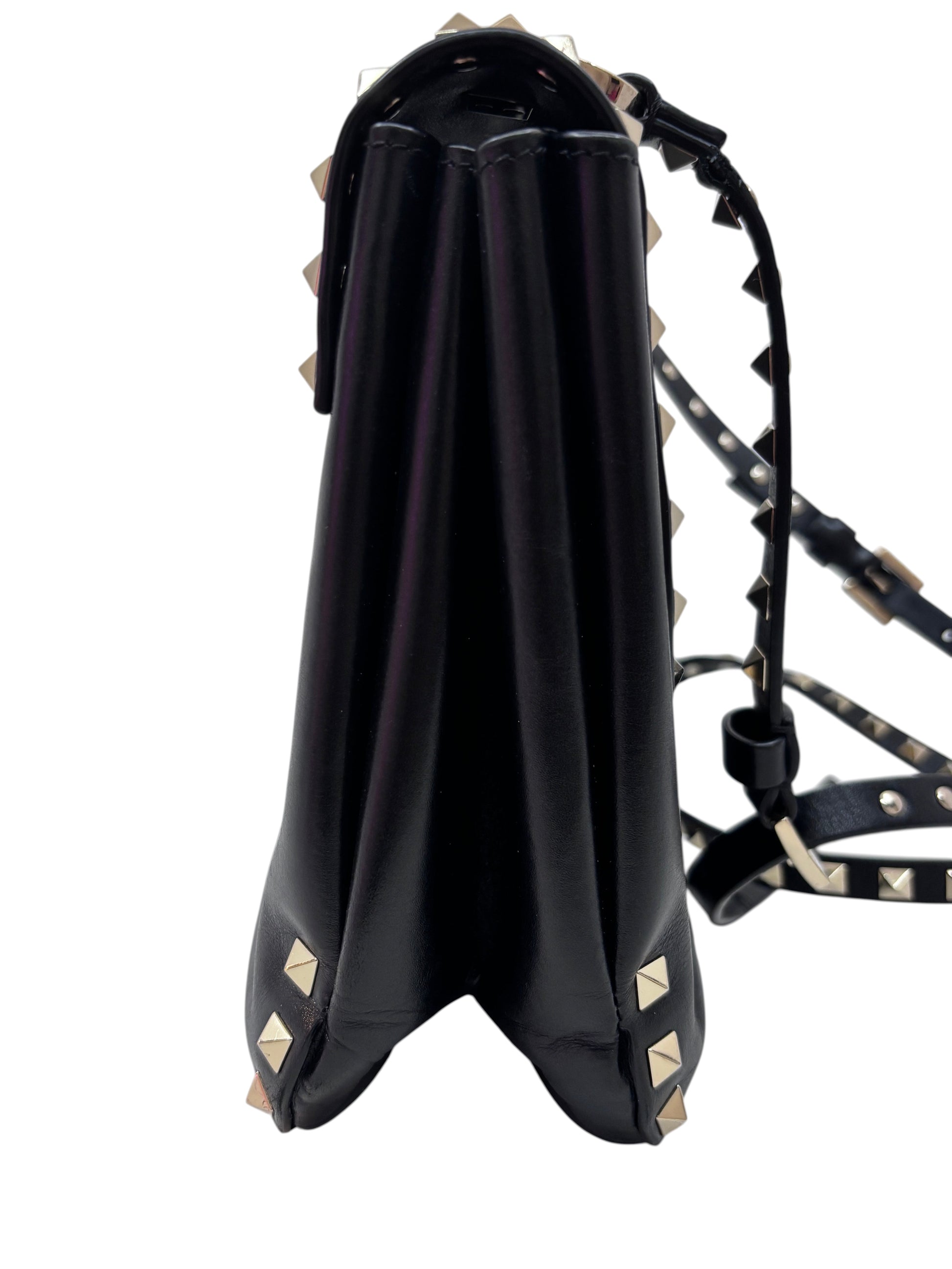 Side view of a black Posh Purse Co. Valentino Rockstud flap bag featuring signature gold studs and a shoulder strap.