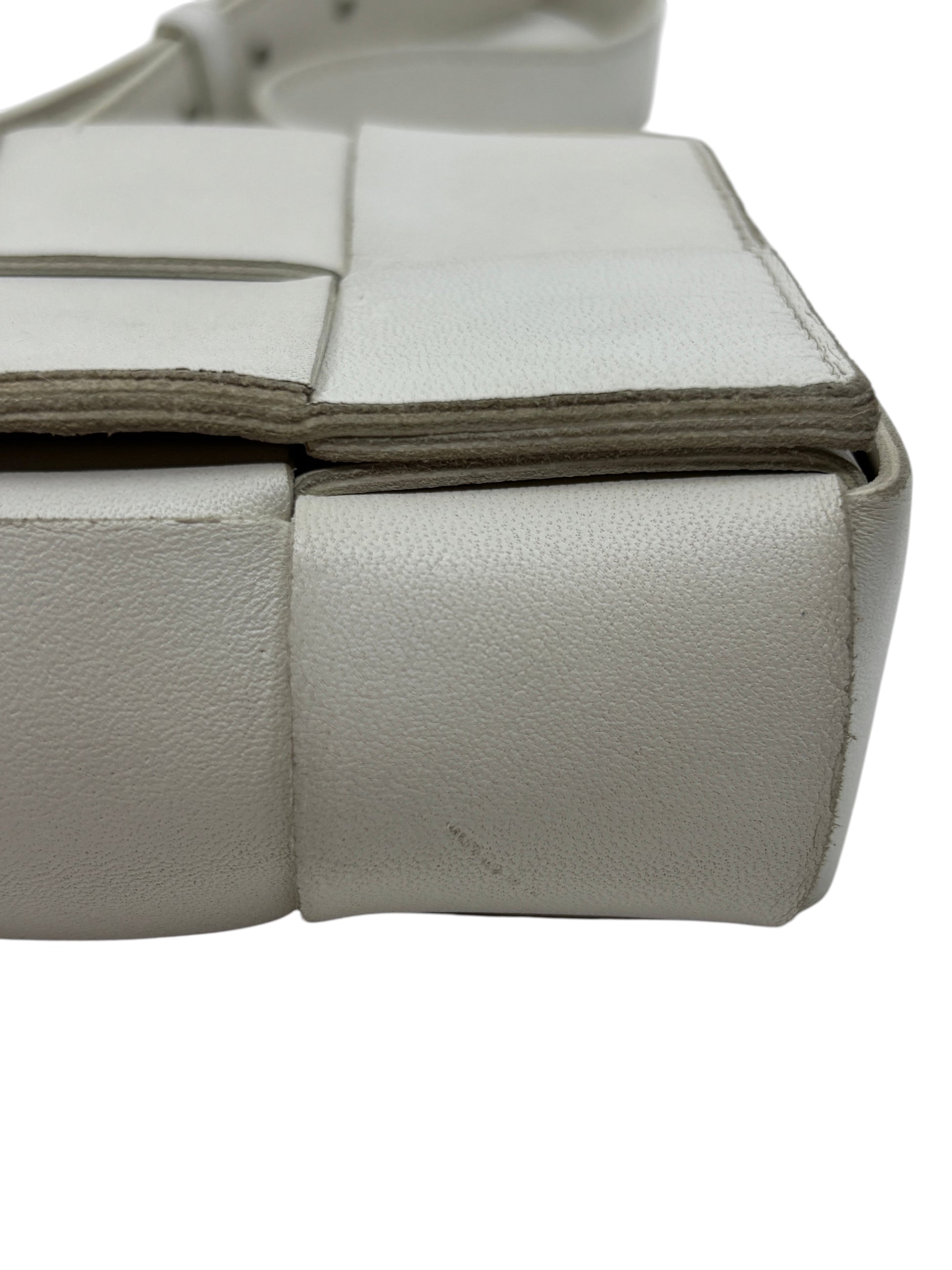 Close-up of Posh Purse Co white Bottega Veneta Cassette bag showing the signature padded Intrecciato woven leather detail.