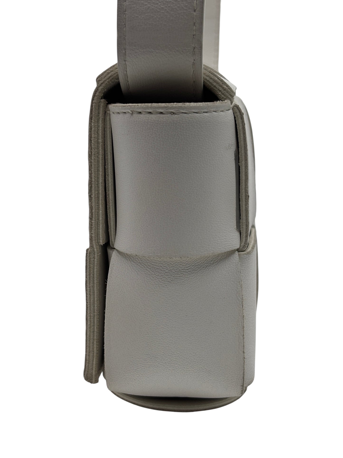 Side view of a white Bottega Veneta Cassette bag in woven leather from Posh Purse Co, showing the structured profile.