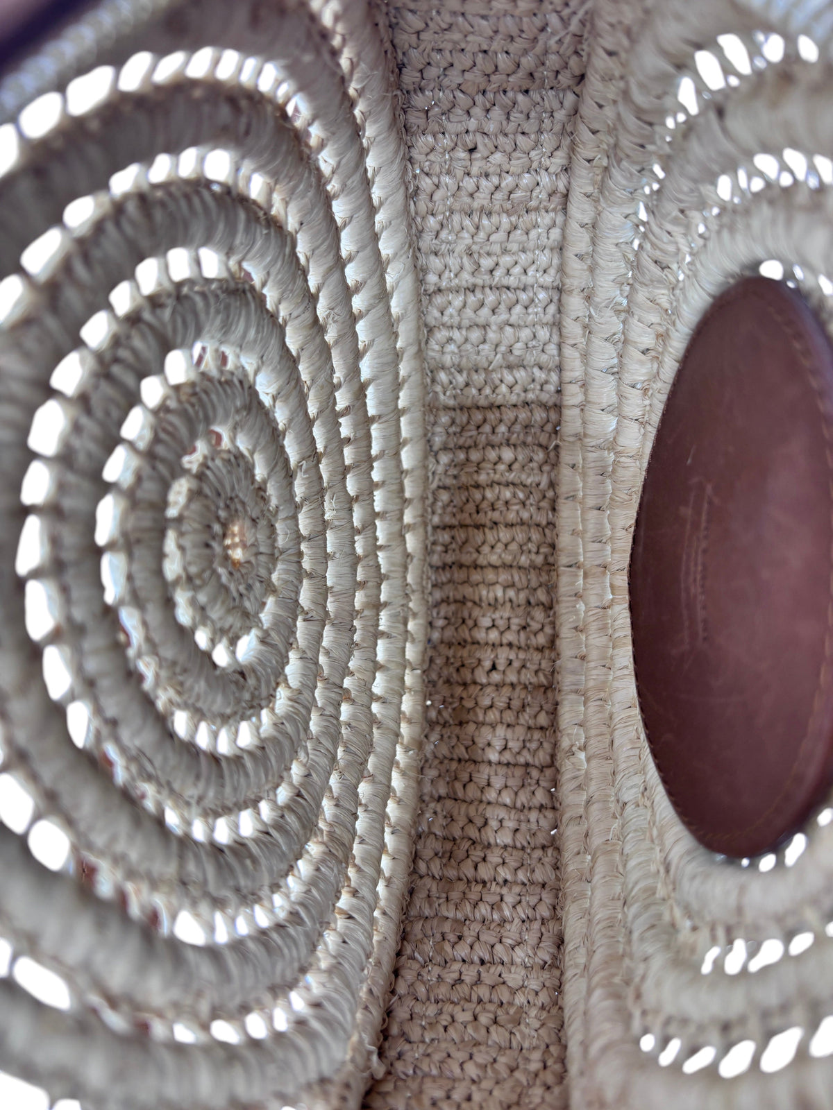 Interior view of Posh Purse Co YSL Raffia Sac Rond bag showing woven natural raffia texture and brown leather pocket