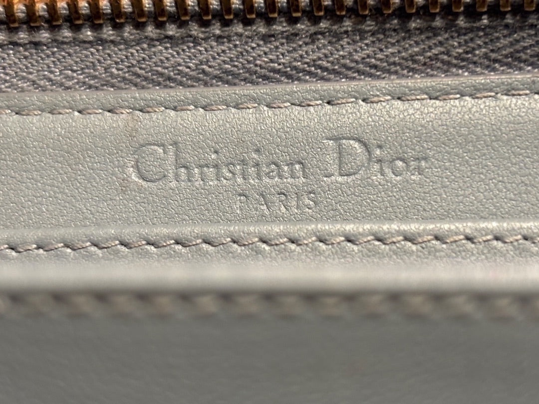 Posh Purse Co. light blue leather Christian Dior wallet with embossed logo and gold zipper detail.