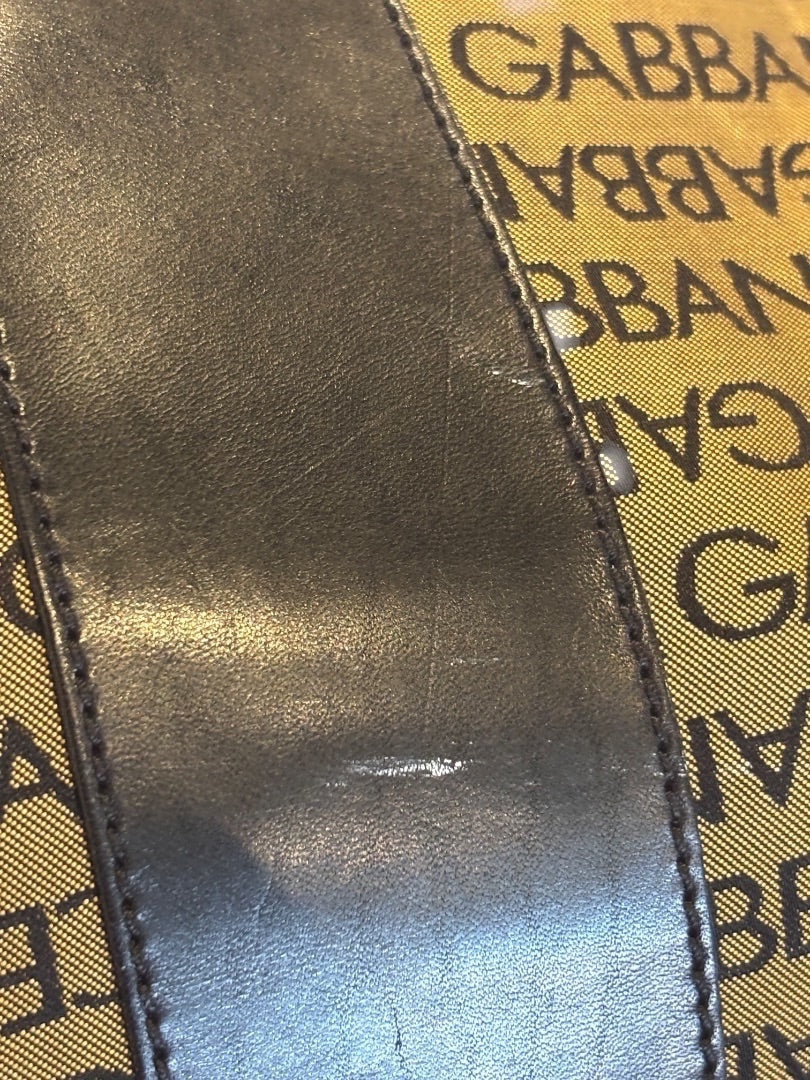 Posh Purse Co Dolce & Gabbana black leather trim on tan canvas duffel bag with all-over logo print.
