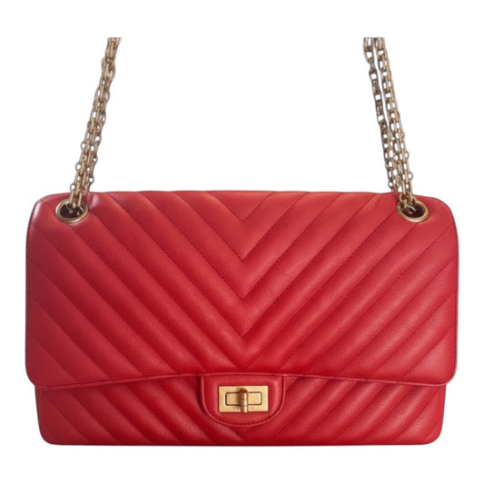 Posh Purse Co. red chevron quilted leather Chanel 2.55 Reissue double flap bag with gold chain strap and Mademoiselle lock.